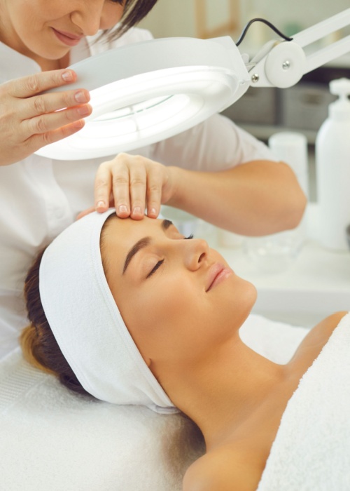 female dermatologist looking at client's face