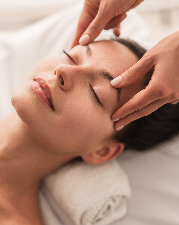Young woman receiving facial massage therapy