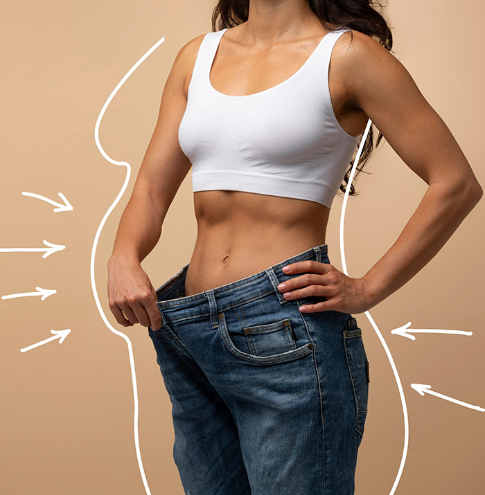 Woman holding loosely-fitting pants as part of medical weight loss concept