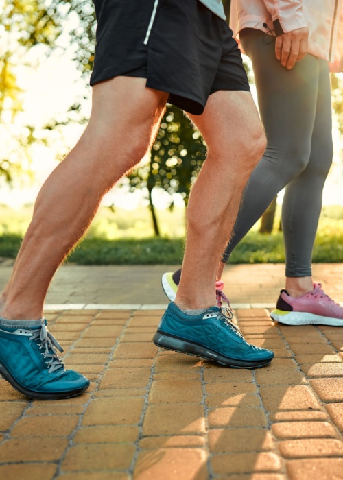 man and woman walking on cobblestone path outdoors