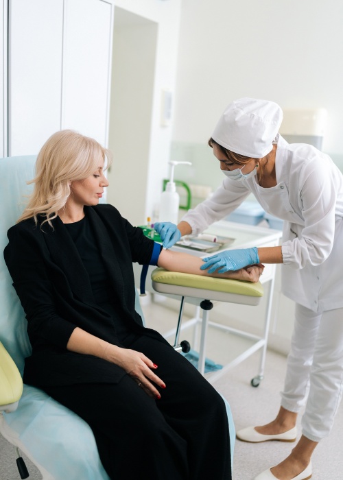 Doctor preparing patients hand to draw blood