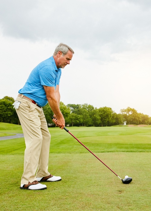older man playing golf