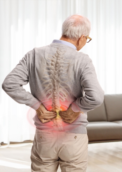 elderly man in pain holding his lower back with red painful spot