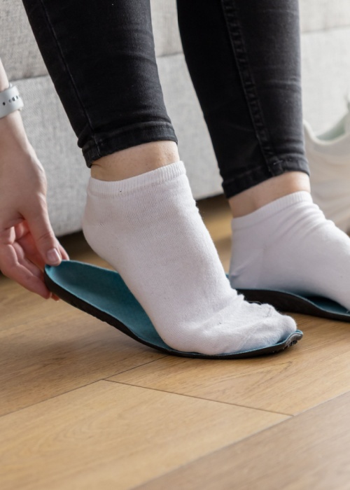 hands fitting blue orthopedic insole