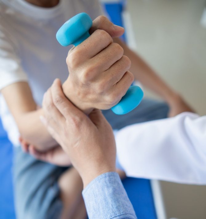 doctor is checking for muscle injuries and using dumbbells test injury