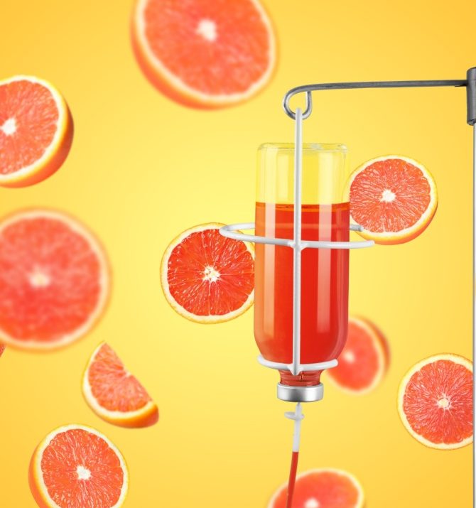 IV infusion set and falling grapefruits on orange background